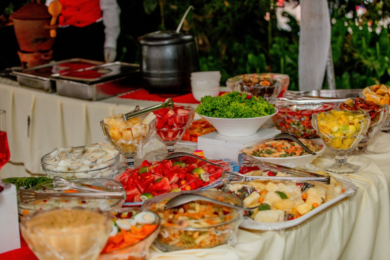 Vibrant display of fresh fruits and salads on a buffet table outdoors.